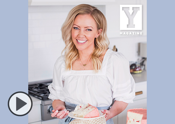 Courtney Rich is a self-taught baker, obsessed with cake. She is pictured here smiling in her kitchen holding a fork and, surprise, a plate of cake.