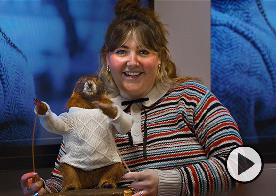A BYU Ad Lab student with a groundhog wearing a sweater.