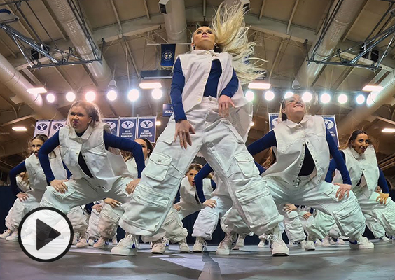 The BYU Cougarettes perform a hip-hop routine, while flipping their long hair and wearing baggy white pants and jackets.