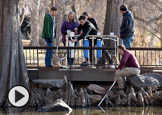 The BYU engineering students test their water filtration device at the campus duck pond.