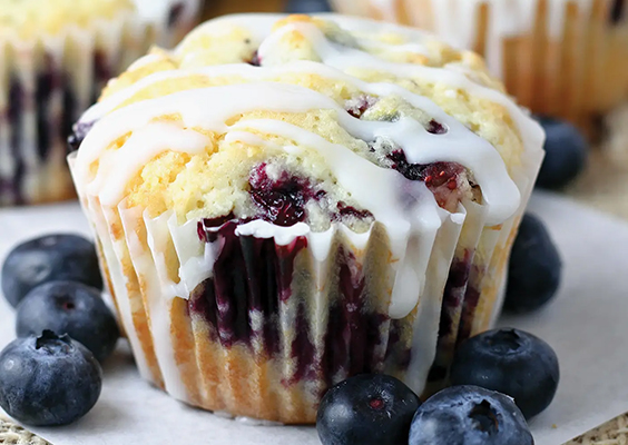 Cloesup of a lemon blueberry muffin with drizzled frosting.