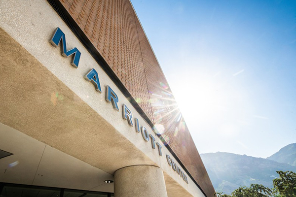 The sun streams down on the facade of the Marriott Center.