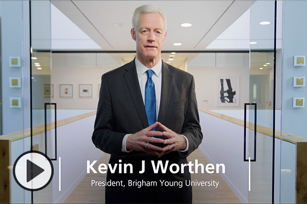 Kevin J Worthen, President, Brigham Young University, is framed by glass doors and white walls.