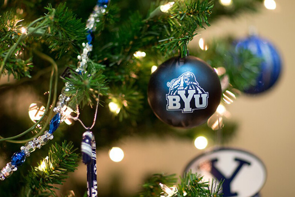 A Christmas tree is a decorated with blue ornaments showing the BYU logo.