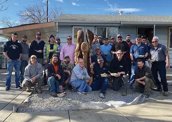 Brett Mickelsen and his volunteer team break for lunch outside a recent Hammers ’N Angels home makeover. Photo by Donna Larson.