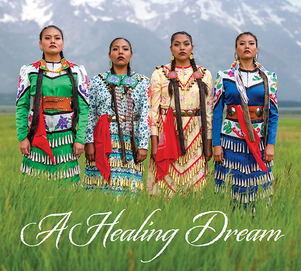 A Healing Dream is the text that accompanies an image of four jingle dress dancers standing in tall grass in front of the Grand Tetons.