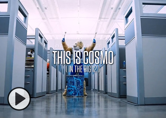 BYU Mascot Cosmo COugar pounds a drum near Big 12 office cubicles.