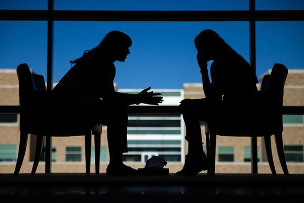 Two sihouetted women sit in facing chairs to illustrate research from BYU professors Timothy Smith and Julianne Holt-Lunstad that found that interpersonal relationships are key parts of medical treatment plans and help patients reduce stress and live longer.