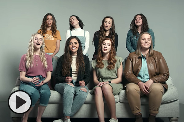 Eight female singers on a couch.