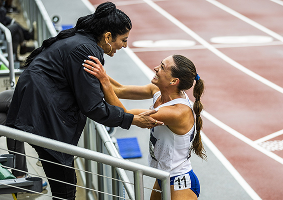 NCAA steeplechase champion Courtney Wayment and her coach Diljeet Taylor embrace and celebrate with huge smiles in the stands next to the track. .