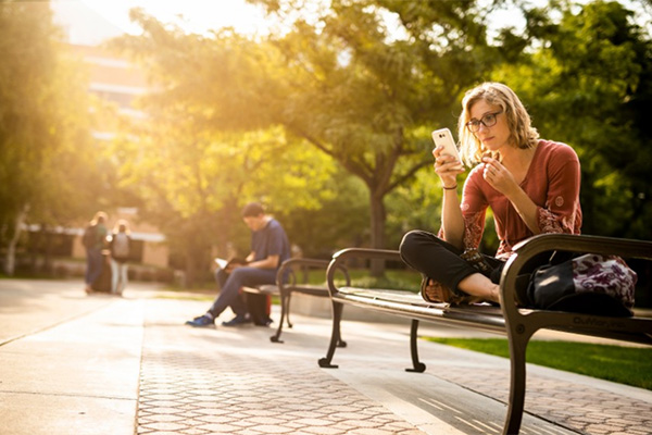 A female BYU student looks at her phone.