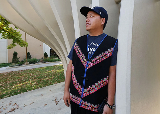 Yang Vang, a BY master's candidate in anthropology, stands near the Tree of Wisdom sculpture on campus, in Provo on Oct. 13. Vang is also a world-renowned Hmong shaman. Photo by Jeffrey D. Allred, Deseret News.