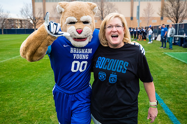 Caroline Billings and Cosmo cheer during a women's soccer game.