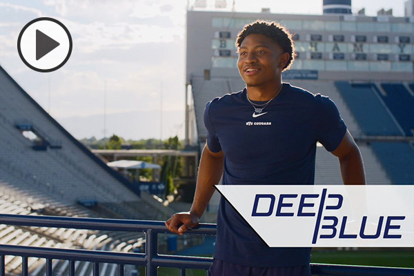 Malik Moore leans on a railing at Lavell Edwards Stadium. The words Deep Blue are at bottom right.