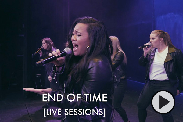 The female singers of BYU Noteworthy hold microphones and sing in unison. They wear matching leather jackets and white t-shirts as they perform on a soundstage. Text says End of Time Live Sessions.