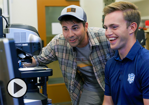 Mark Rober and a BYU student engineer laugh as they work to activate a miniature Nerf blaster.