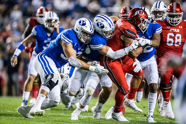 BYU football players gang tackle an opposing running back.