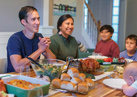 A family gathers at the dinner table to share time, stories, and food.