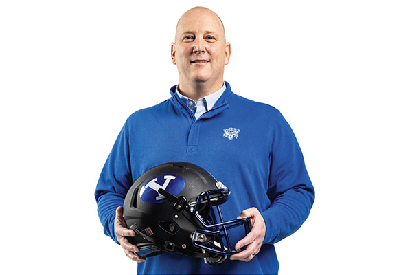 Darren Campbell, BYU’s head doctor, holds a black BYU football helmet.