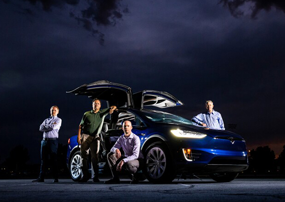 BYU professors (L-R) Eric Homer, James Patterson, Oliver Johnson, and Eric Sevy stand next to the DeLorean-like falcon-wing doors of a Tesla X. Unfortunately, the Tesla cannot time travel. Photo by Nate Edwards/BYU Photo.