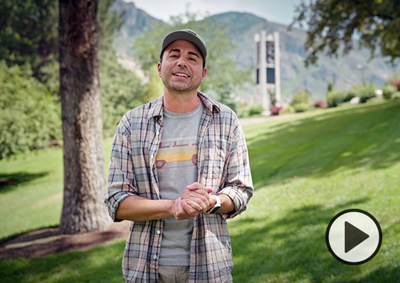 YouTuber Mark Rober stands on a BYU campus hill near the Carillon Bell Tower.