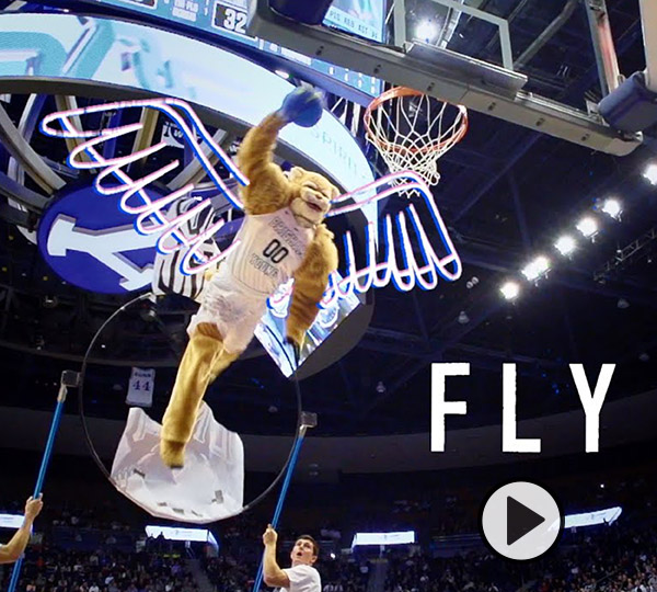 Cosmo sprouts animated wings, soars above the Marriott Center rim, and prepares to dunk a blue basketball.