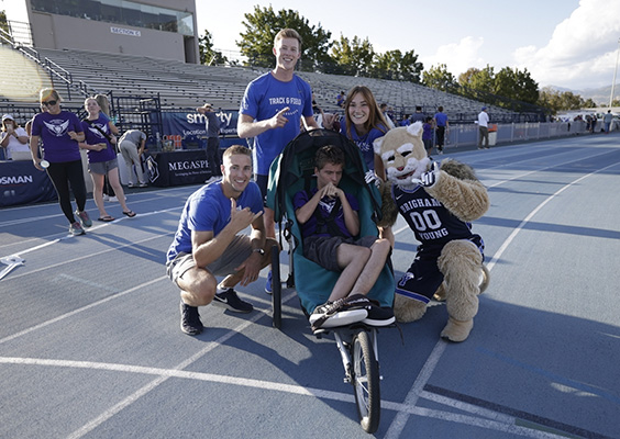 Cosmo, BYU track athletes, and kids with health challenges gather on BYU's outdoor track.